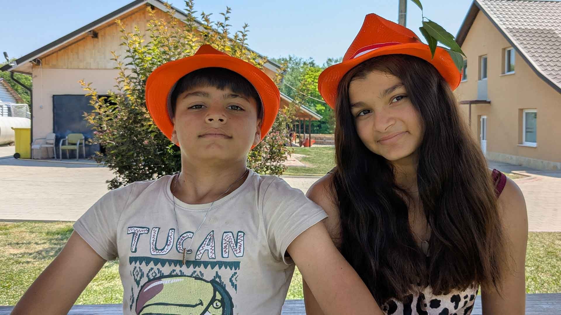 A brother and sister sit together at summer camp.