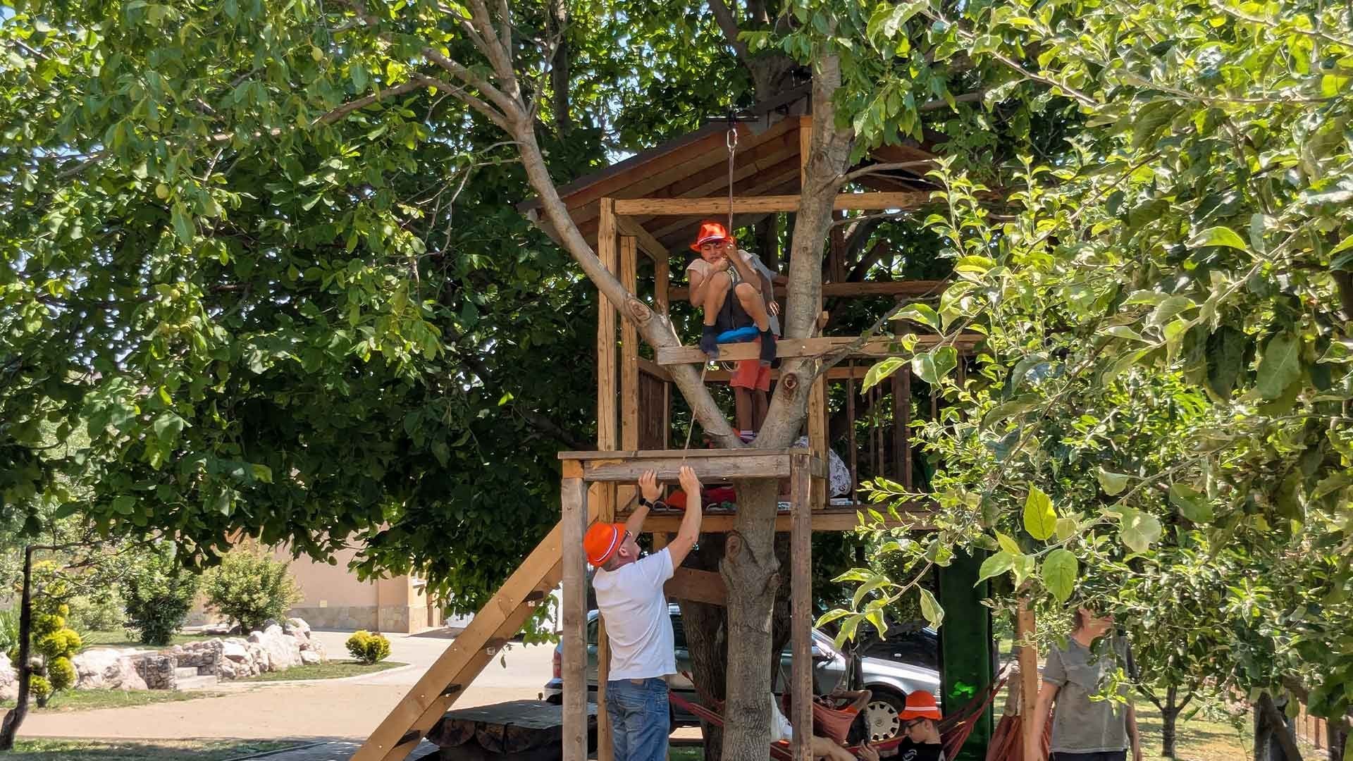 A boy sits on a zipwire.