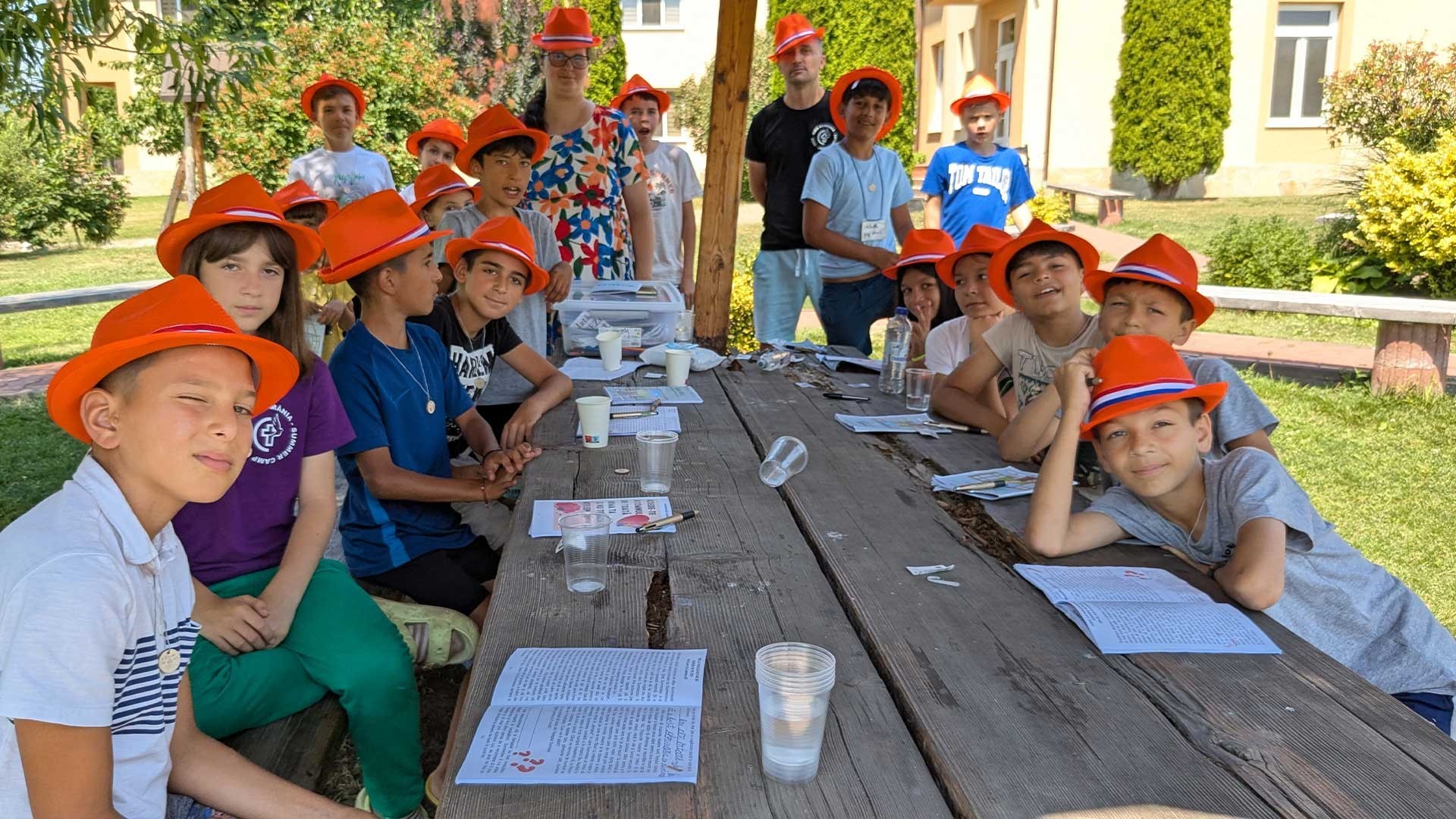 A group of children sit smiling round a table.